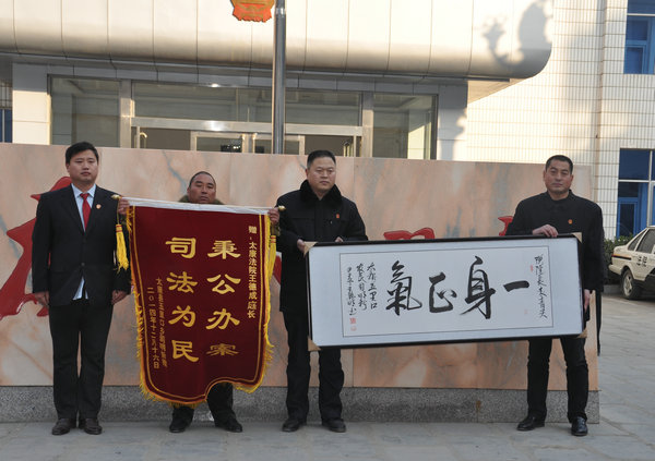 河南省太康县五里口乡村民司明将一块书写"一身正气"的书法牌匾和一面